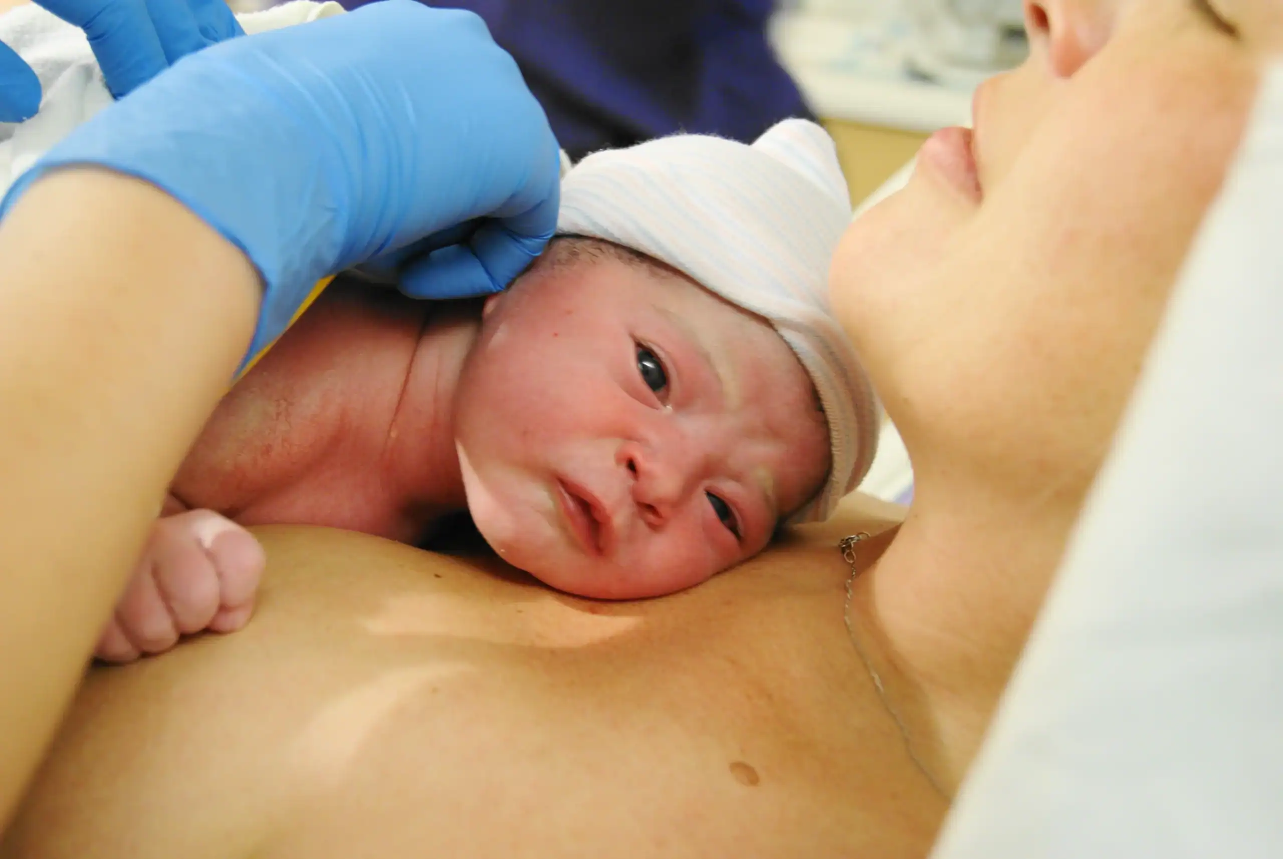 Newborn baby skin to skin with mother after a beautiful vaginal hospital birth.