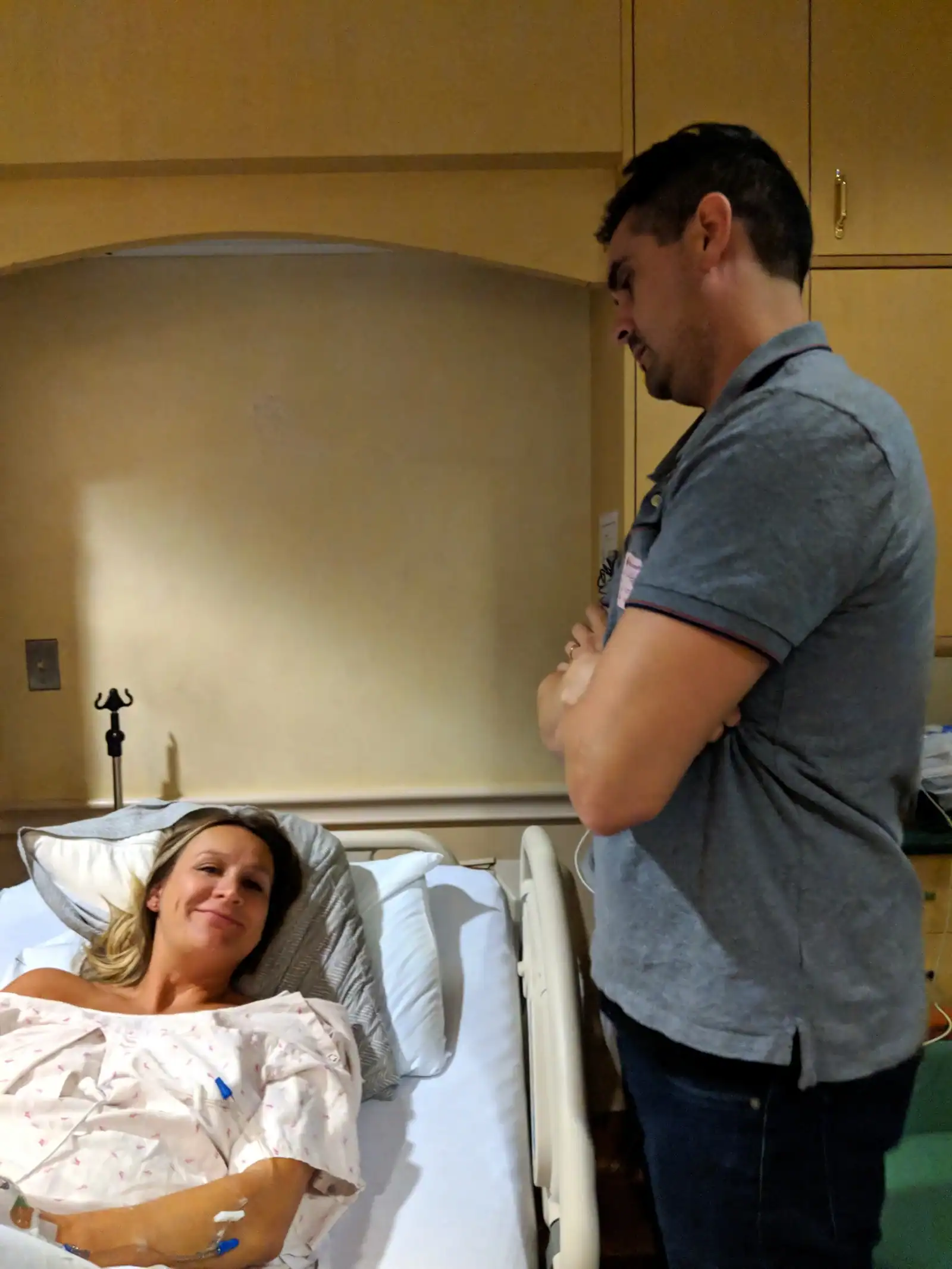 Doula providing emotional support to a woman in labor in a hospital room.