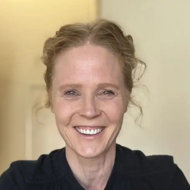 Smiling woman providing doula support, promoting joyful birth experiences.