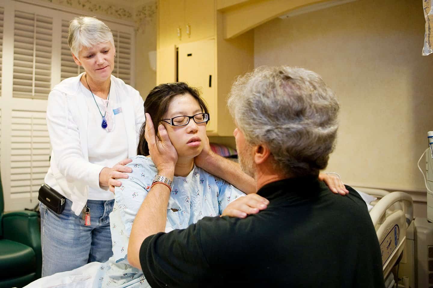 A laboring woman in transition being support by her partner and doula.