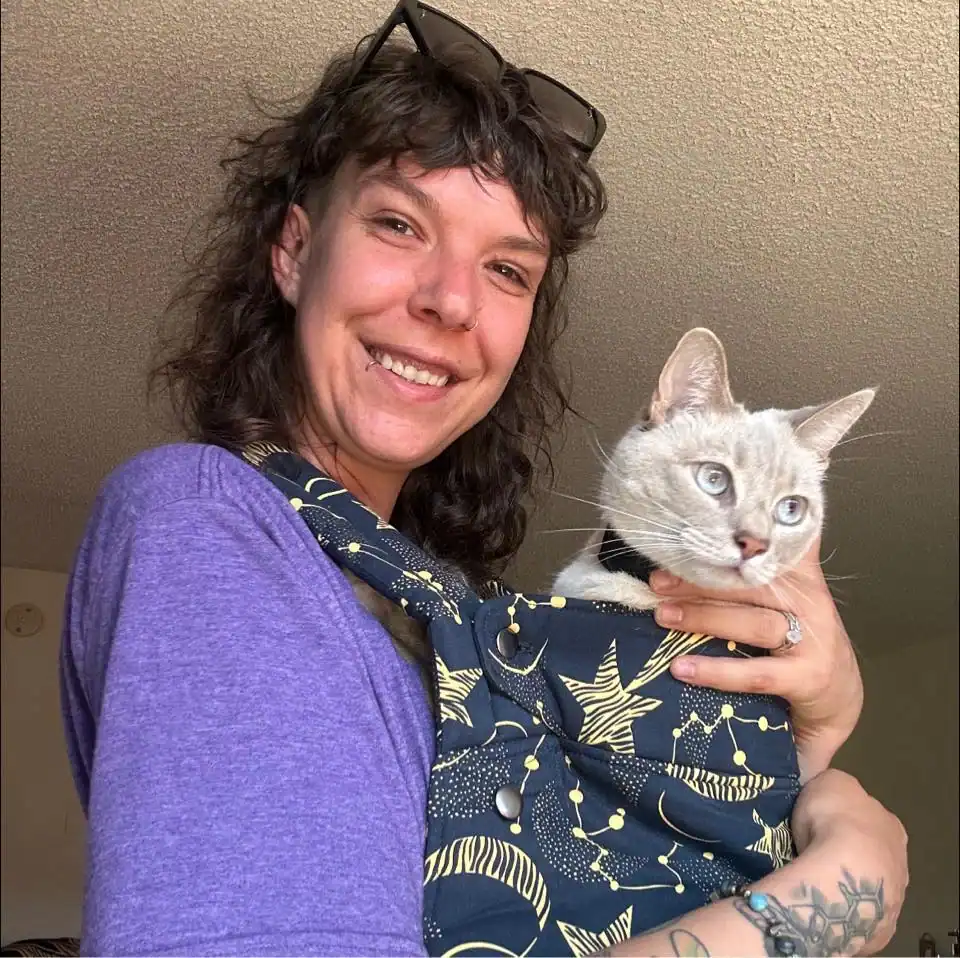 Comforting doula holding a cat, providing support and care for families during childbirth.