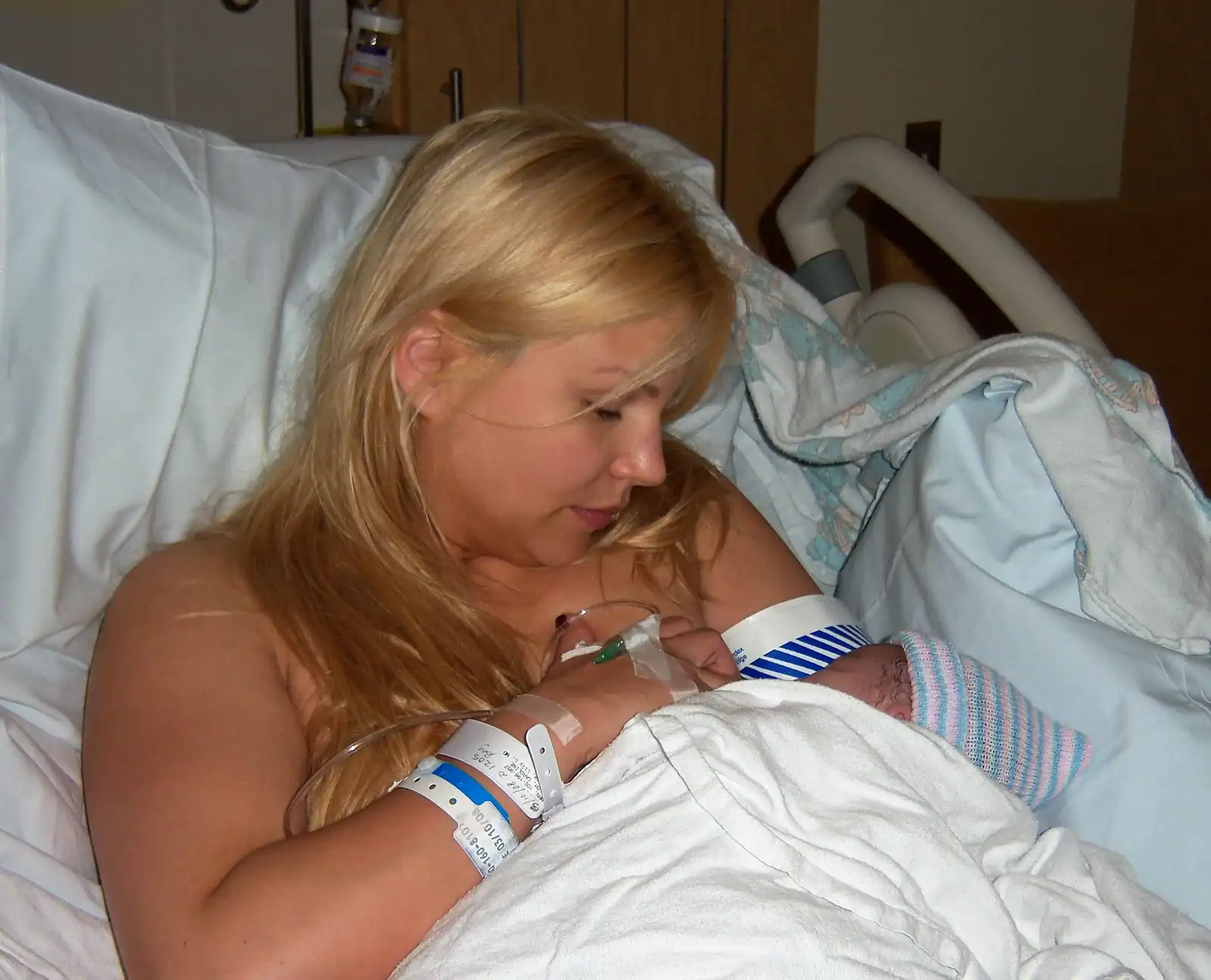 Mother holding her newborn baby, showcasing postpartum care and maternal bonding.