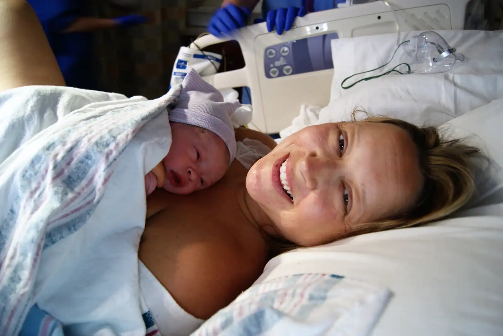 Newborn baby and mother in hospital after birth, showcasing doula support and postpartum care.
