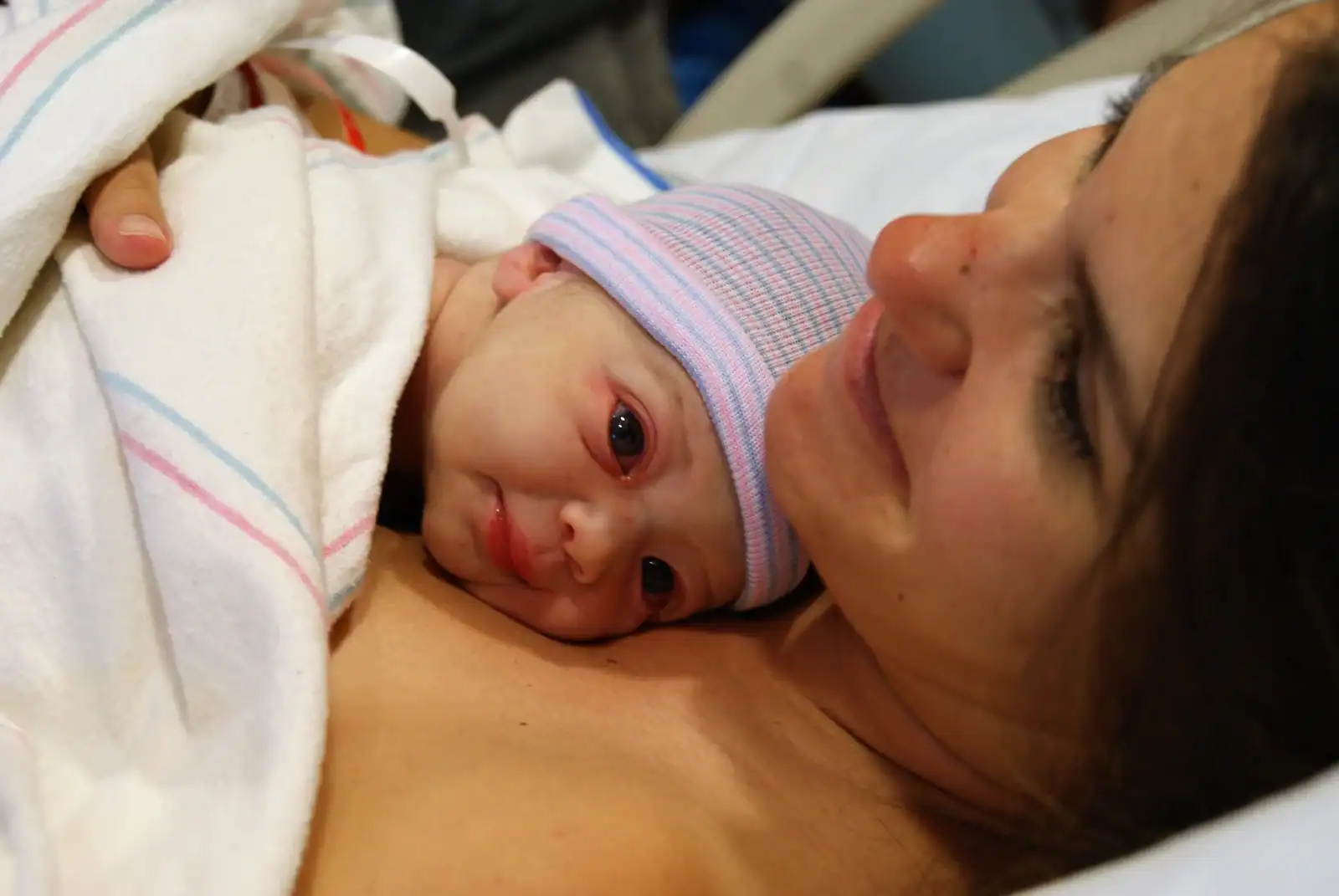 Newborn baby skin-to-skin on mother's chest. Happy mother.