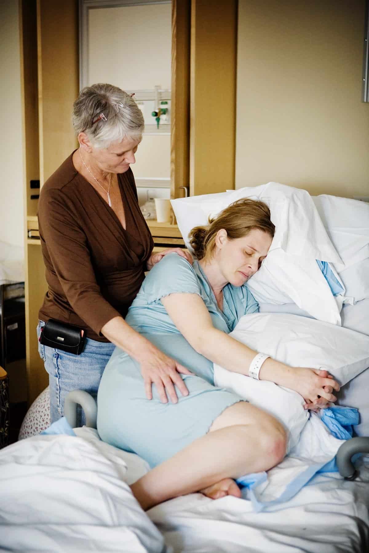 Doula providing emotional and physical support to a woman in labor.